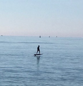 man on electric surfboard at sandbanks beach